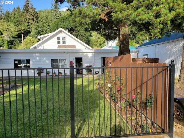 view of front of house with a fenced front yard and a front lawn