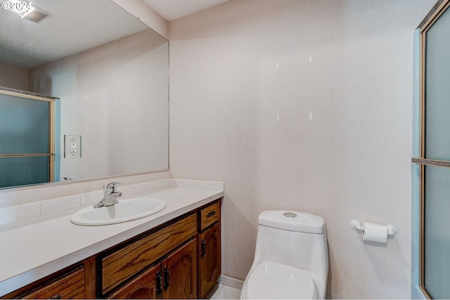 bathroom featuring vanity, toilet, and an enclosed shower