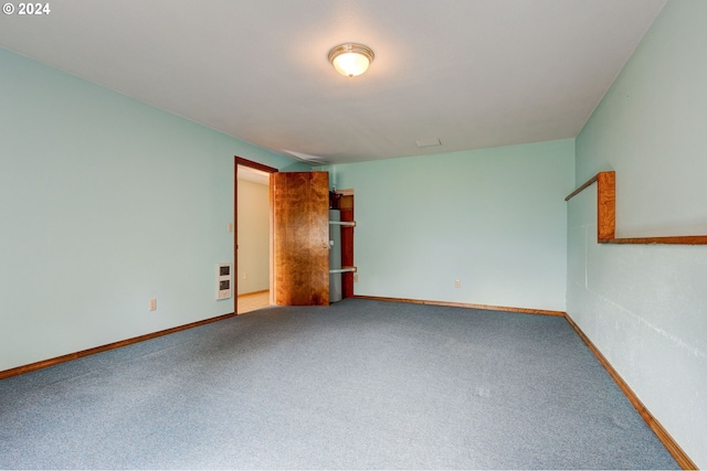 unfurnished room featuring carpet floors and heating unit