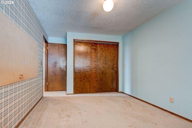 unfurnished bedroom featuring a closet, a textured ceiling, and carpet floors