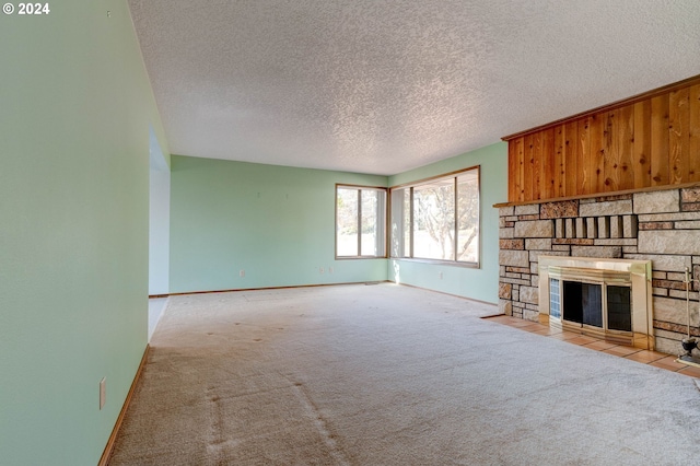 unfurnished living room featuring a textured ceiling, light carpet, and a fireplace