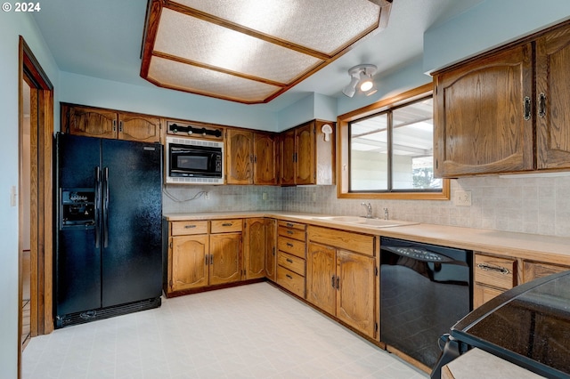 kitchen with black appliances, sink, and decorative backsplash