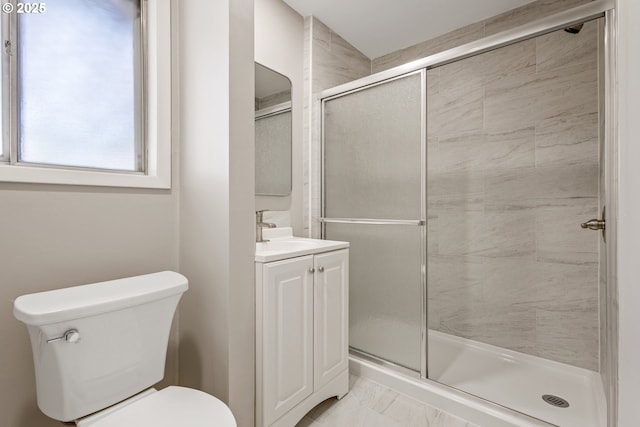 bathroom featuring vanity, a shower with door, and toilet