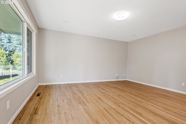 empty room with light hardwood / wood-style flooring and a textured ceiling