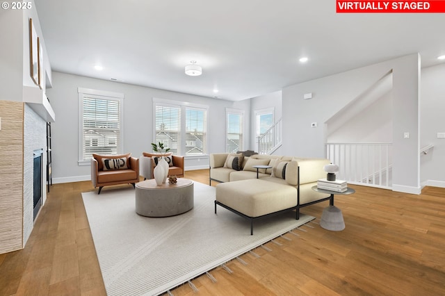 living room with light hardwood / wood-style floors and a healthy amount of sunlight