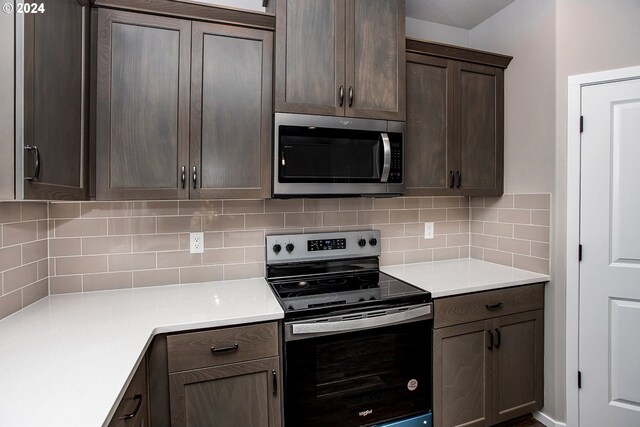 kitchen featuring backsplash, dark brown cabinets, and stainless steel appliances