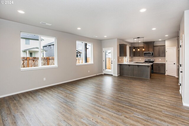 unfurnished living room with plenty of natural light and dark wood-type flooring