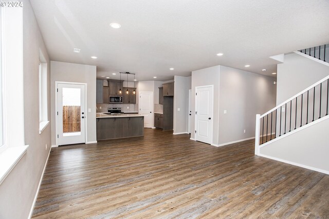 unfurnished living room featuring a textured ceiling and dark wood-type flooring