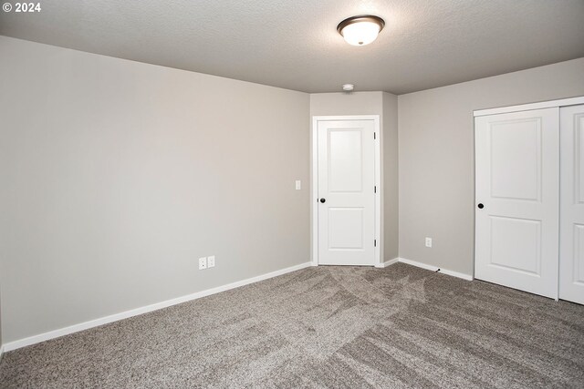 carpeted spare room with a textured ceiling