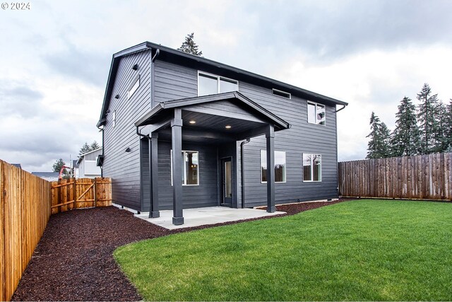 rear view of property featuring a patio and a lawn