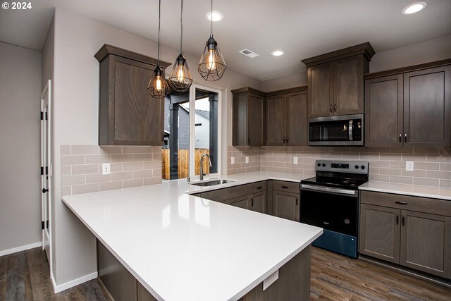 kitchen with kitchen peninsula, dark hardwood / wood-style flooring, hanging light fixtures, and appliances with stainless steel finishes