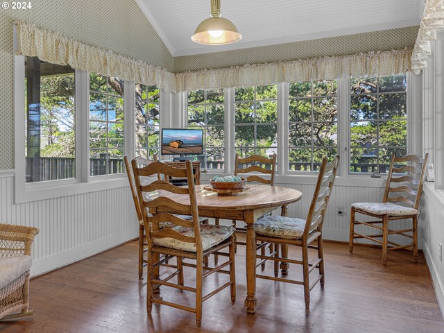 dining area with hardwood / wood-style flooring, lofted ceiling, and ornamental molding