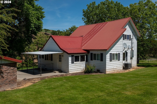 back of house featuring a yard and cooling unit