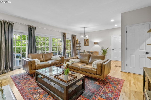 living room featuring light hardwood / wood-style floors and a notable chandelier