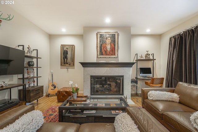 living room featuring a tiled fireplace and hardwood / wood-style floors