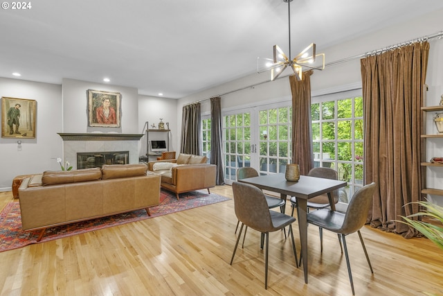 dining area with an inviting chandelier and light hardwood / wood-style flooring