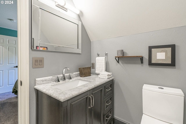 bathroom with vanity, toilet, and vaulted ceiling