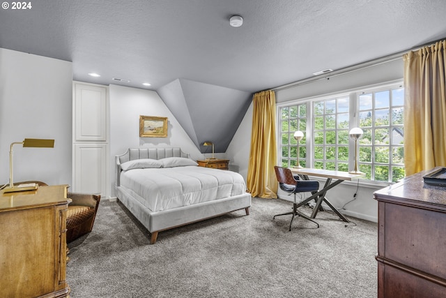 bedroom featuring dark colored carpet, a textured ceiling, and lofted ceiling