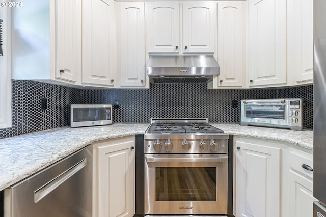 kitchen featuring white cabinets, stainless steel appliances, and extractor fan