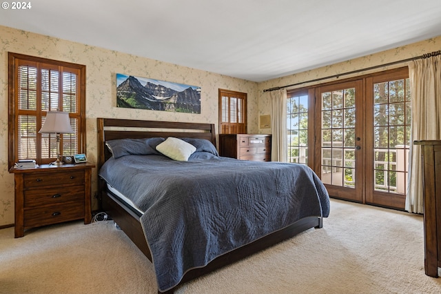 bedroom with access to outside and light carpet