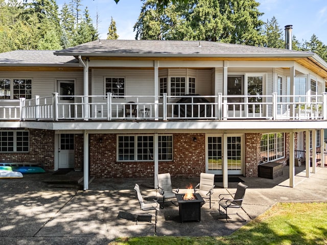 back of house featuring an outdoor fire pit and a patio