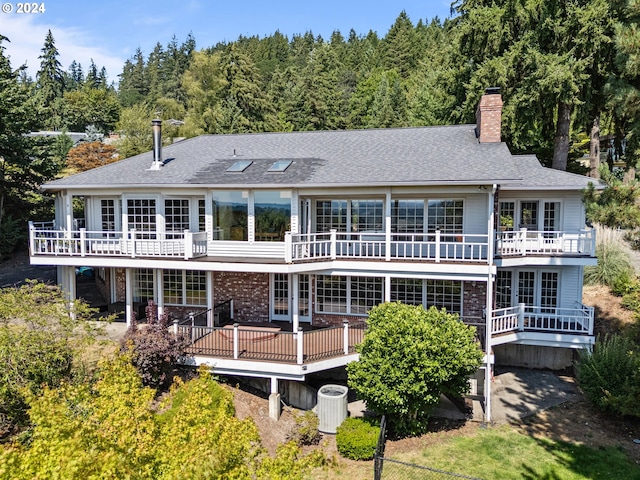 rear view of house with central AC unit and a deck