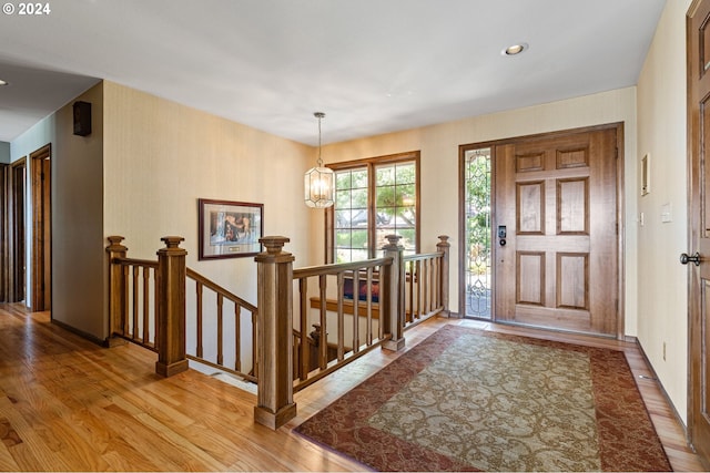 foyer entrance featuring an inviting chandelier and light hardwood / wood-style flooring