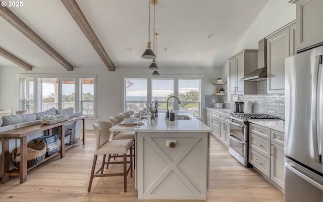 kitchen with stainless steel appliances, a center island with sink, tasteful backsplash, gray cabinetry, and sink