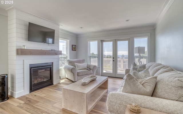 living room featuring french doors, ornamental molding, a wealth of natural light, and light hardwood / wood-style flooring