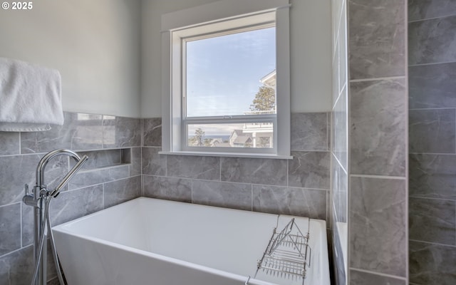 bathroom with a tub to relax in and a wealth of natural light