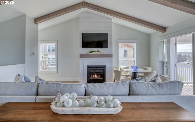 living room with a large fireplace, lofted ceiling with beams, and wood-type flooring