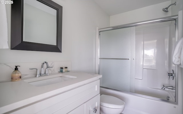 full bathroom featuring toilet, vanity, and bath / shower combo with glass door