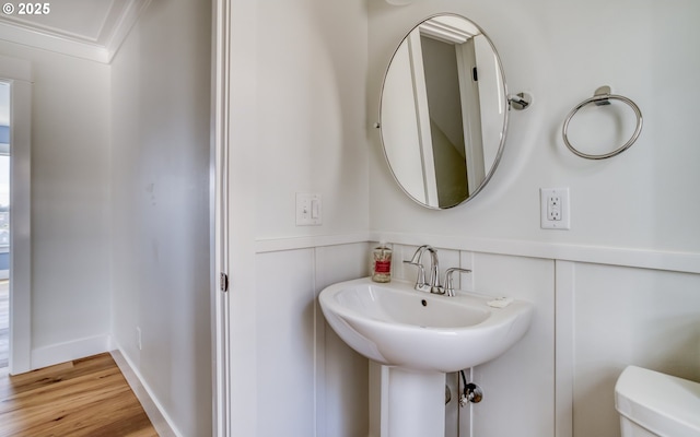 bathroom featuring sink, hardwood / wood-style floors, crown molding, and toilet