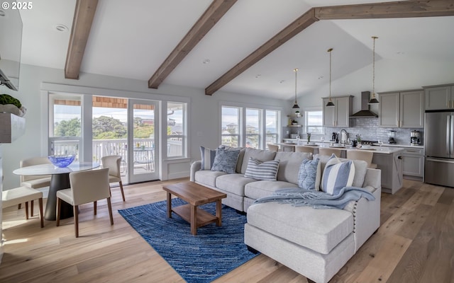 living room with beamed ceiling, high vaulted ceiling, light hardwood / wood-style floors, and a healthy amount of sunlight