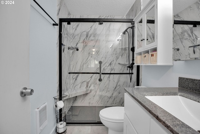 bathroom with a textured ceiling, an enclosed shower, vanity, and toilet