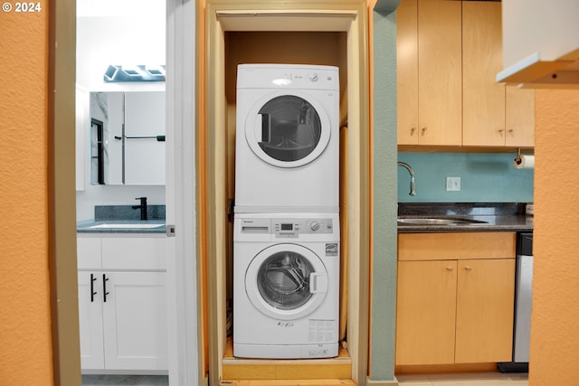 laundry area with sink and stacked washer / dryer