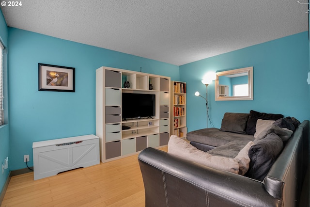 living room featuring a textured ceiling and wood-type flooring