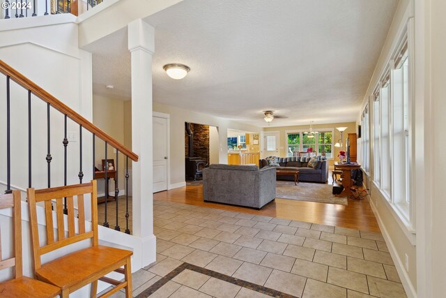 living room with a textured ceiling, decorative columns, and light hardwood / wood-style floors