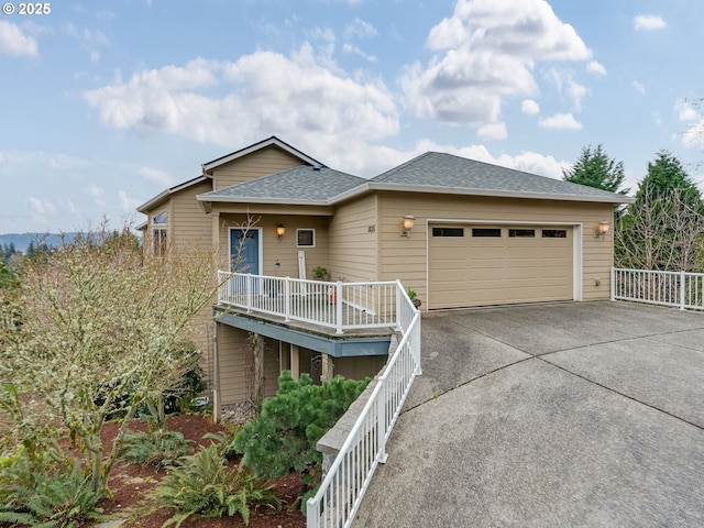 view of front of property with roof with shingles, concrete driveway, and an attached garage