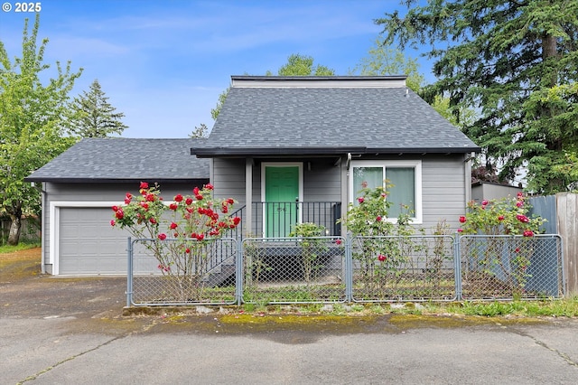 8941 SE Knapp St, Portland, OR 97266 - view of front of house with roof with shingles, a fenced front yard, an attached garage, and driveway