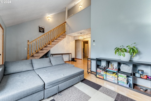 8941 SE Knapp St, Portland, OR 97266 - living room featuring stairs, wood finished floors, and high vaulted ceiling
