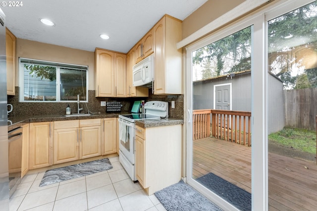 kitchen featuring backsplash, light brown cabinetry, sink, and white appliances