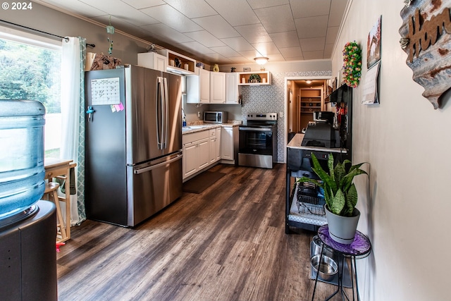 kitchen with ornamental molding, white cabinetry, dark hardwood / wood-style flooring, and stainless steel appliances