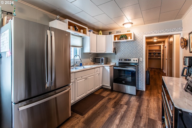 kitchen featuring appliances with stainless steel finishes, sink, dark wood-type flooring, and white cabinets