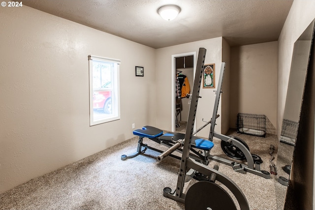 exercise area featuring a textured ceiling and carpet floors