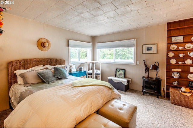 carpeted bedroom featuring a wood stove