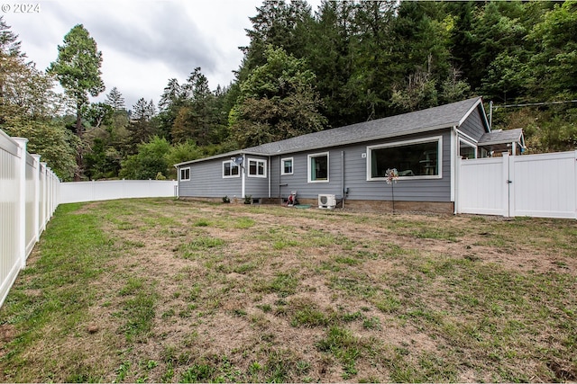 back of house with a lawn and central AC