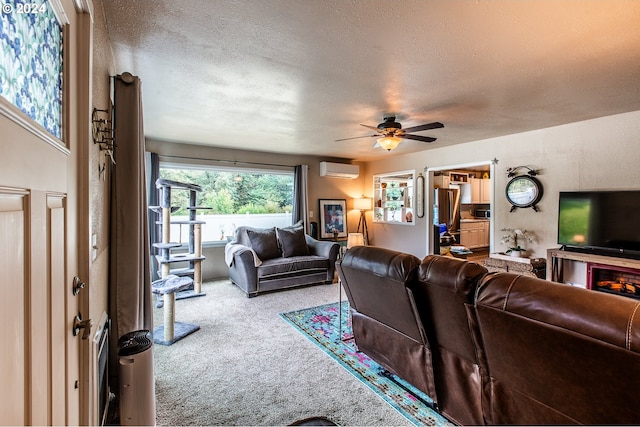 living room with an AC wall unit, ceiling fan, carpet flooring, and a textured ceiling