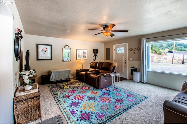 carpeted living room with a textured ceiling and ceiling fan