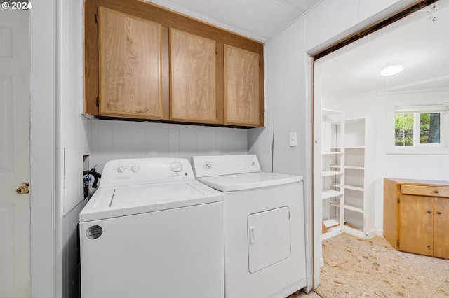 laundry room featuring cabinets and washing machine and clothes dryer